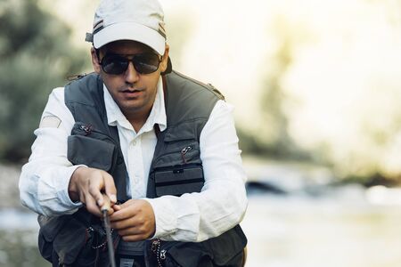 Fly fisherman using flyfishing rod in beautiful river.の写真素材