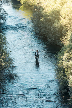 Fly fisherman using flyfishing rod in beautiful river.の写真素材