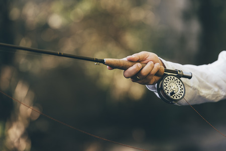 Fly fishing rod in fisherman hand.の写真素材