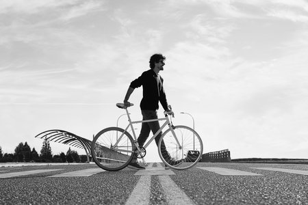 Outdoor portrait of handsome young man with fixed gear bicycle in the street.の写真素材