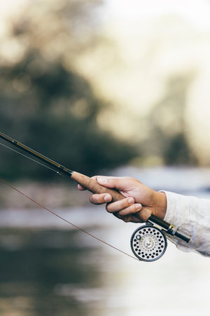 Fly fishing rod in fisherman hand.