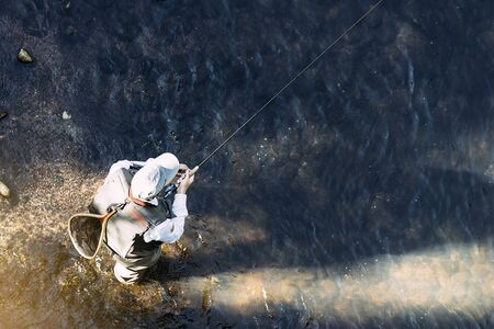 Fly fisherman using flyfishing rod in beautiful river.の写真素材