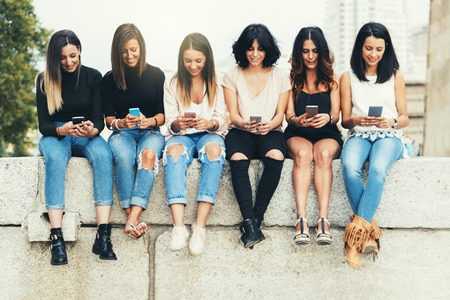 Big Group of friends using cellphones in the street.の写真素材