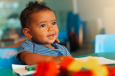 Happy baby playing with toy blocks in the kindergarten.の写真素材