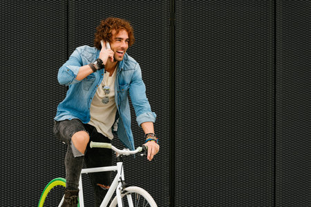 Handsome young man with mobile phone and fixed gear bicycle in the street.の写真素材