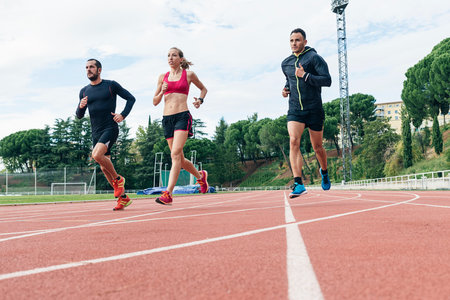 Group of young  athletics people running on the track fieldの写真素材