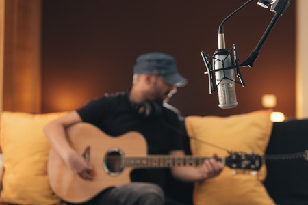 Young man singing in direct on musical studio.の写真素材