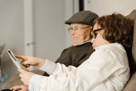 Grandfather and grandson are taking selfie at home.の写真素材