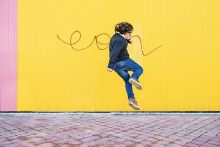 Happy boy jumping in the street.の写真素材