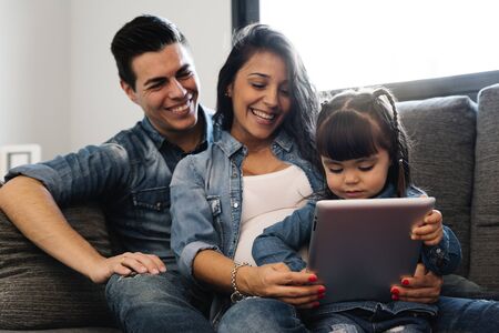 Happy family using tablet at home.の写真素材