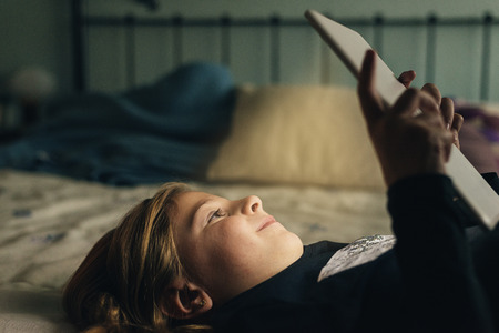 Sweet blondie girl playing on a Tablet PC.の写真素材