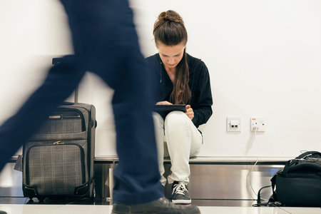 Young backpacker woman waiting for her flight at airport