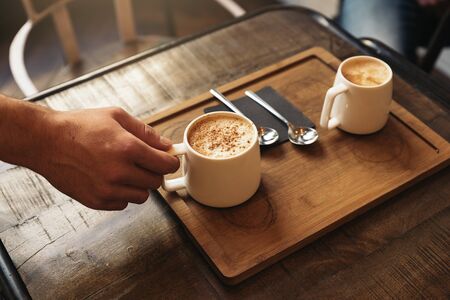 Waiter holding a tray with coffees in the bar.の写真素材