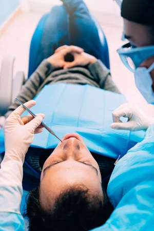 Dentists with a patient during a dental intervention. Dentist  Conceptの写真素材