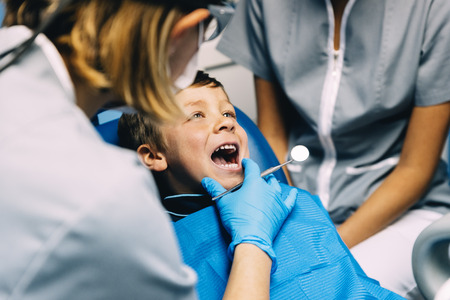 Dentists with a patient during a dental intervention to boy. Dentist  Conceptの写真素材