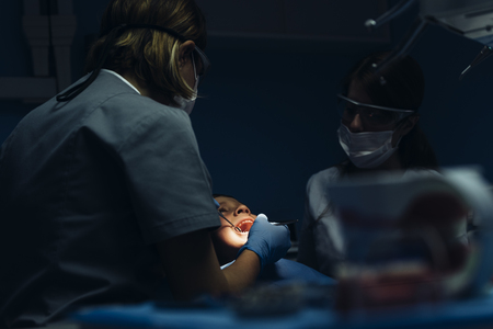 Dentists with a patient during a dental intervention to boy. Dentist  Conceptの写真素材