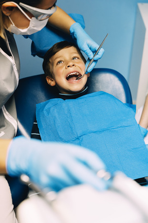 Dentists with a patient during a dental intervention to boy. Dentist  Conceptの写真素材