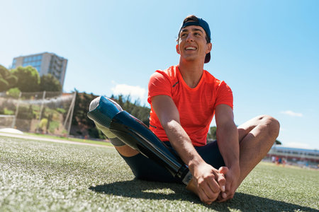 Disabled man athlete stretching with leg prosthesis. Paralympic Sport Concept.の写真素材