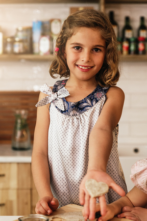 Little girl showing her cookie. Infant Chef Concept.の写真素材