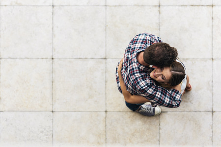 Young loving couple hugging in the street. From top view. Young Love Concept.の写真素材