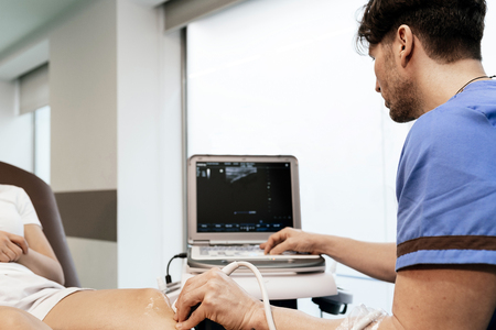 Physiotherapist giving knee therapy to a woman in clinic. Physical treatment conceptの写真素材