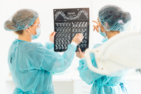 Dentist showing something to her colleague on x-ray image.
