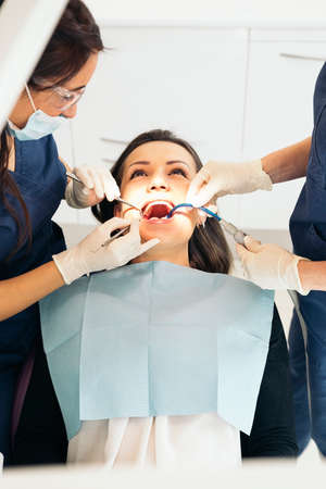 Dentists with a patient during a dental intervention.の写真素材
