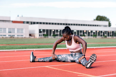 Athlete sprinter stretching her legs