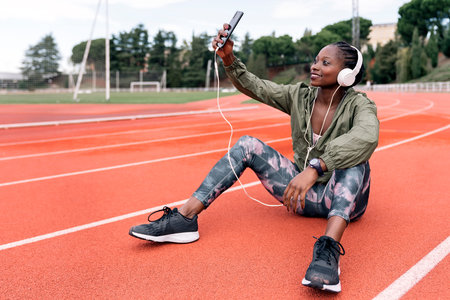 Athlete sprinter sitting listening to music