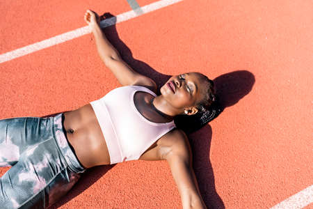 Athlete sprinter lying down on the floorの写真素材