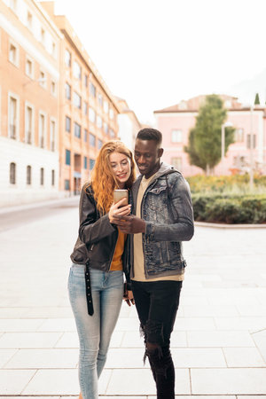 Young Affectionate Couple Using Phoneの写真素材