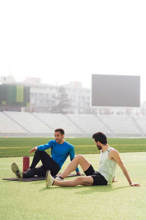 Athletes Stretching in Athletic Trackの写真素材