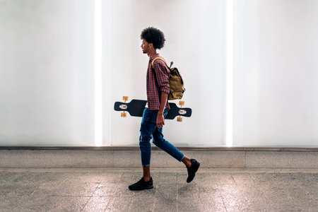 Young Afro Boy with Longboardの写真素材