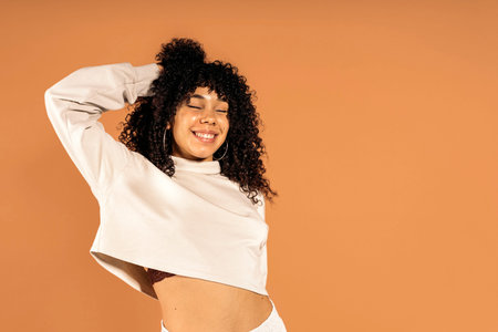 Stock photo of beautiful african woman moving her curly hair in studio shot.