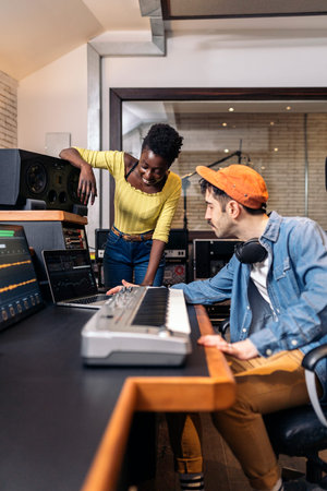 Stock photo of black woman working with male producer in music studio.の写真素材