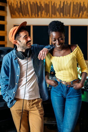 Stock photo of hipster man and black singer smiling in professional music studio.の写真素材