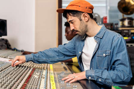 Stock photo of hipster man using control panel in professional music studio.の写真素材