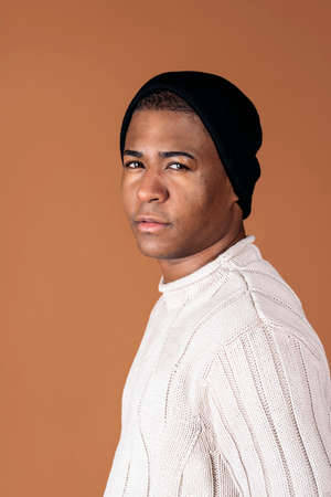 Stock photo of young man wearing casual clothes posing in studio shot against brown background.の写真素材