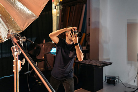 Stock photo of professional photographer during photo shoot in studio.