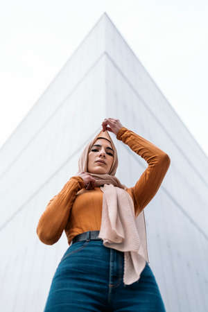 Beautiful young muslim woman wearing hijab standing against white background and looking at camera.の写真素材