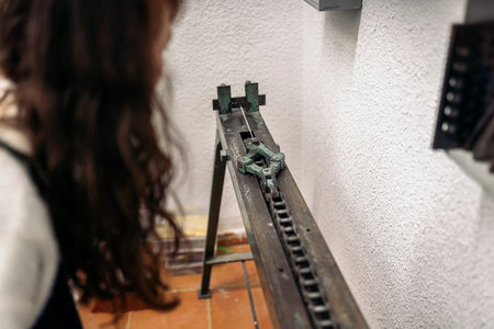 Unrecognized craftswoman working and using special machine in jewelry workshop.の写真素材