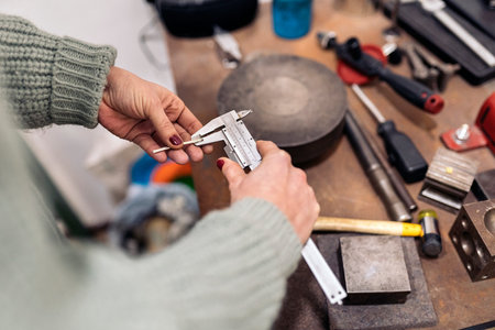 Unrecognized craftswoman working jewelry workshop using tools.の写真素材
