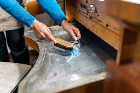 Unrecognized woman working and using tools in jewelry workshop.