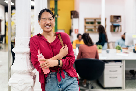 Cheerful asian woman smiling and looking at camera in the office. Coworking concept.の写真素材