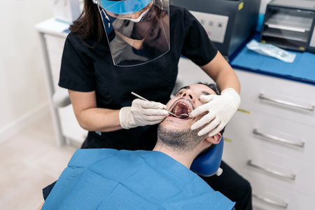 Unrecognized man lying down in dentist chair during checkup revision.の写真素材