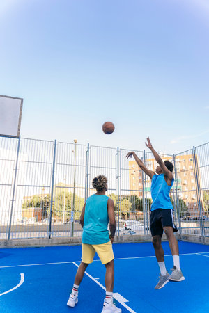 Strong and healthy african friends playing basketball and having fun during sunny day.の写真素材