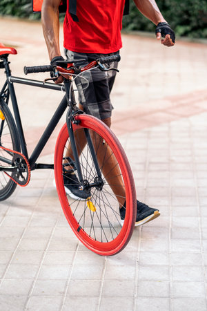 Unrecognized african delivery man walking in the city with his cool bike.の写真素材