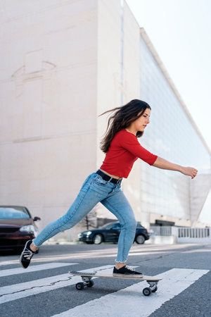 Young skater woman practicing with her longboard in the city and having fun.の写真素材