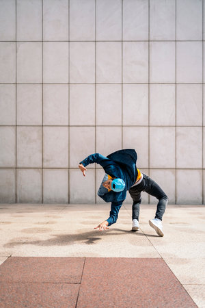 Cool young man doing break dance moves in the city and having fun.の写真素材