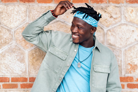 Attractive african boy with dreadlocks smiling and looking to the side.の写真素材